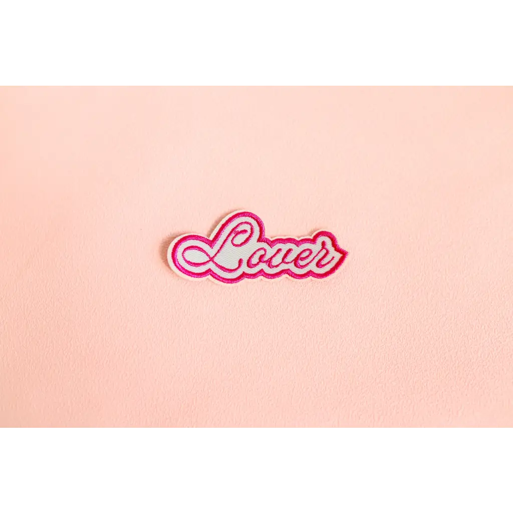 Pink and white cursive text of Lover on a fun iron-on patch for style upgrades