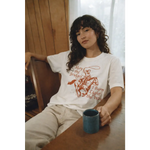 Oversized unisex tee with orange cowboy print and May the Bridges I Burn Light the Way text