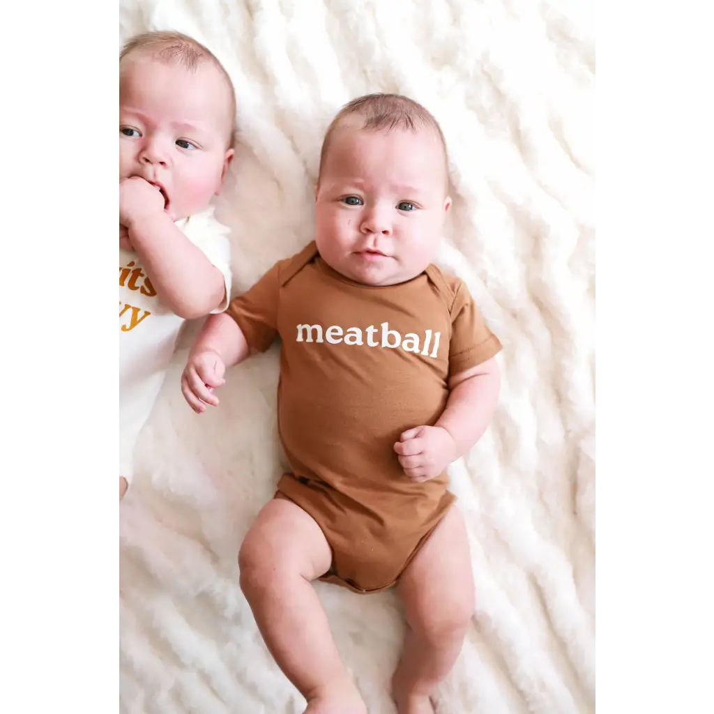 Two babies on white fabric, one in a Meatball Organic Cotton Baby Onesie