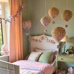 Pastel origami balloon decorations in Meri Meri x Liberty style over bed