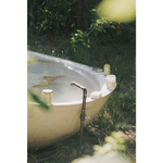 Rustic outdoor bathtub with vintage faucet and Vetiver Bergamot soak