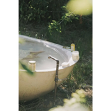Rustic outdoor bathtub with vintage faucet and Vetiver Bergamot soak