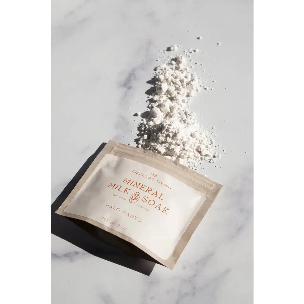 Mineral milk soak sachet with palo santo, white powder spilled from beige pack