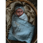 Swaddled baby in a light blue cap with a Mini Cozy Organic Cotton Blanket Bundle