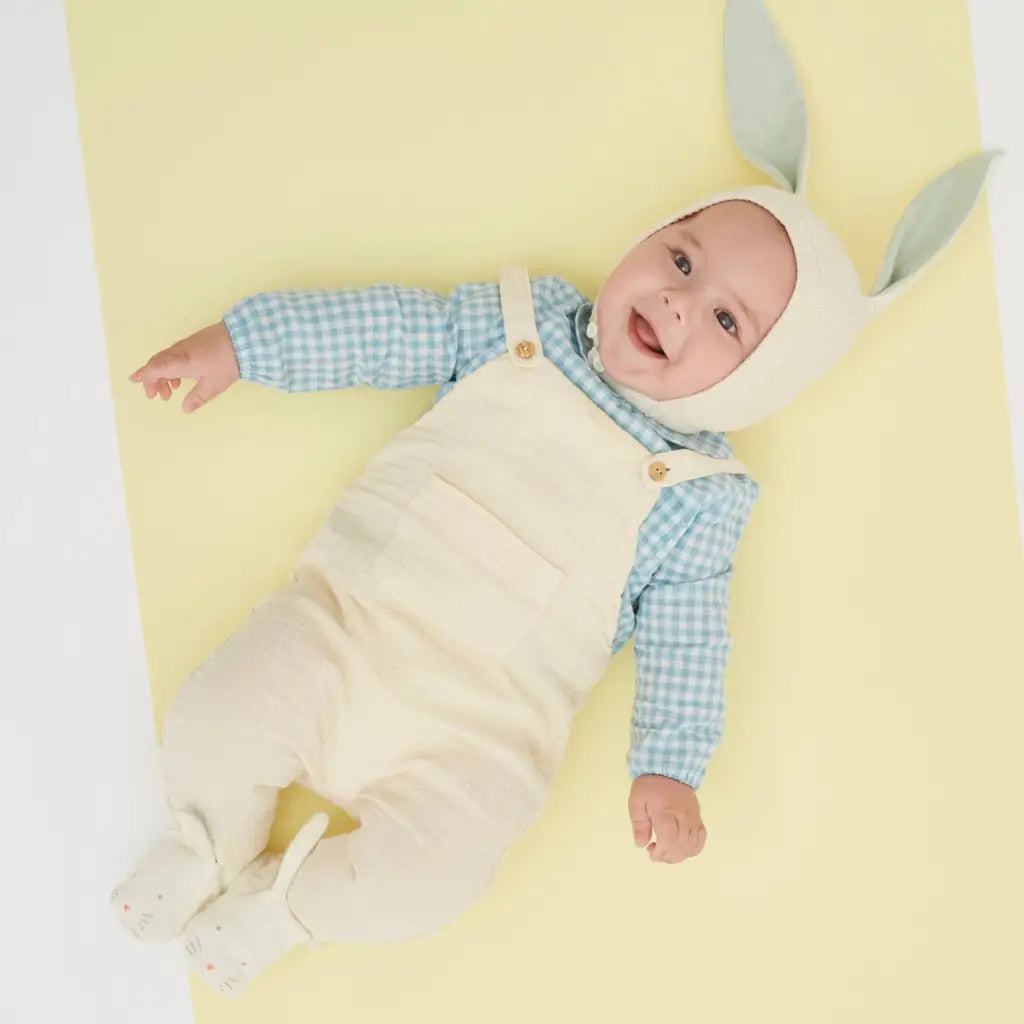 Cute Mint Bunny baby onesie in white overalls, blue checkered shirt, beige hat with gray rabbit ears