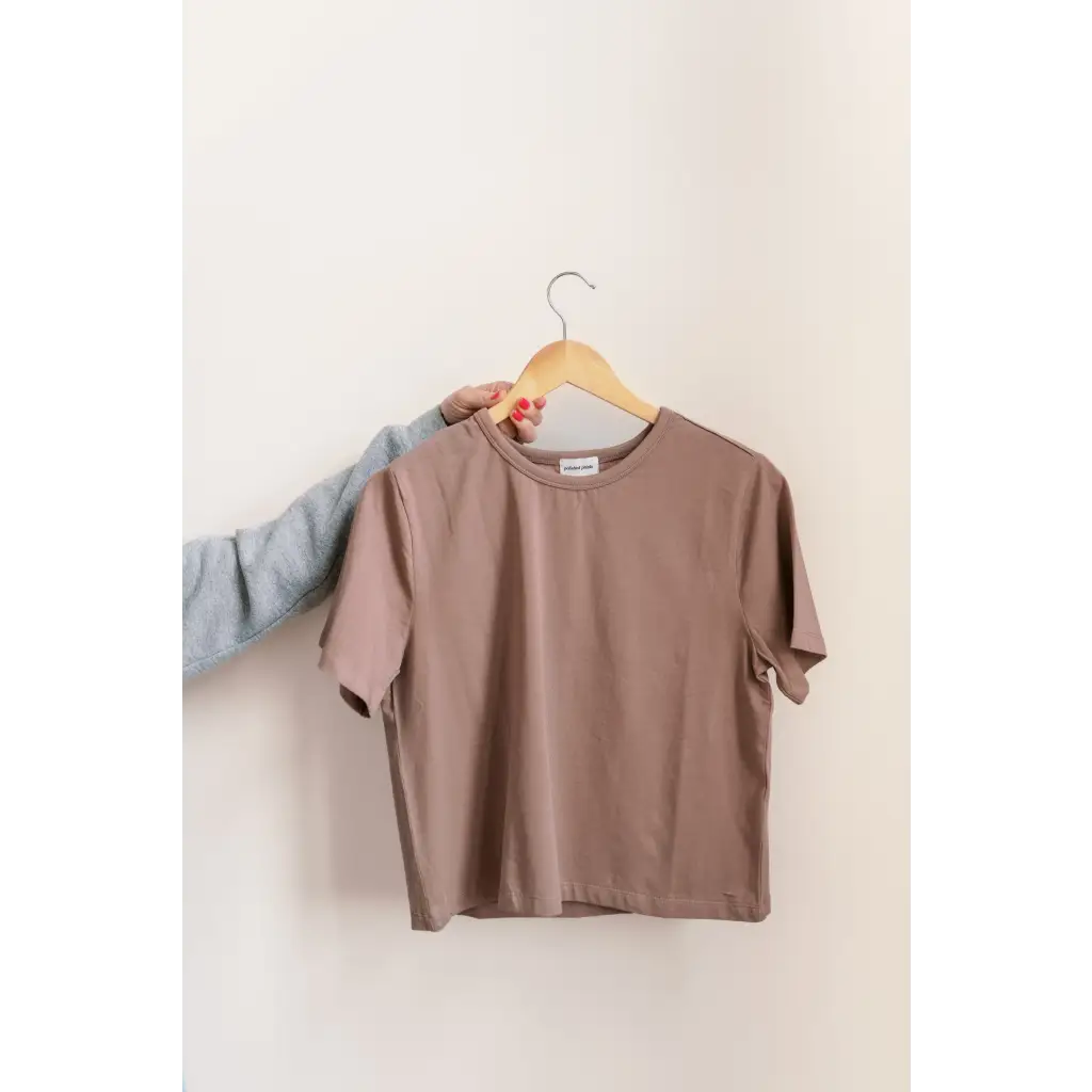 Taupe-colored mom crop boxy tee on a wooden hanger for a casual vibe