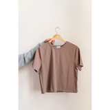 Taupe-colored mom crop boxy tee on a wooden hanger for a casual vibe