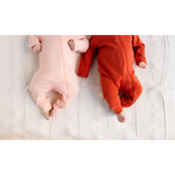 Two babies in pink and red onesies snuggled in a Peace Signs Camp baby gift box