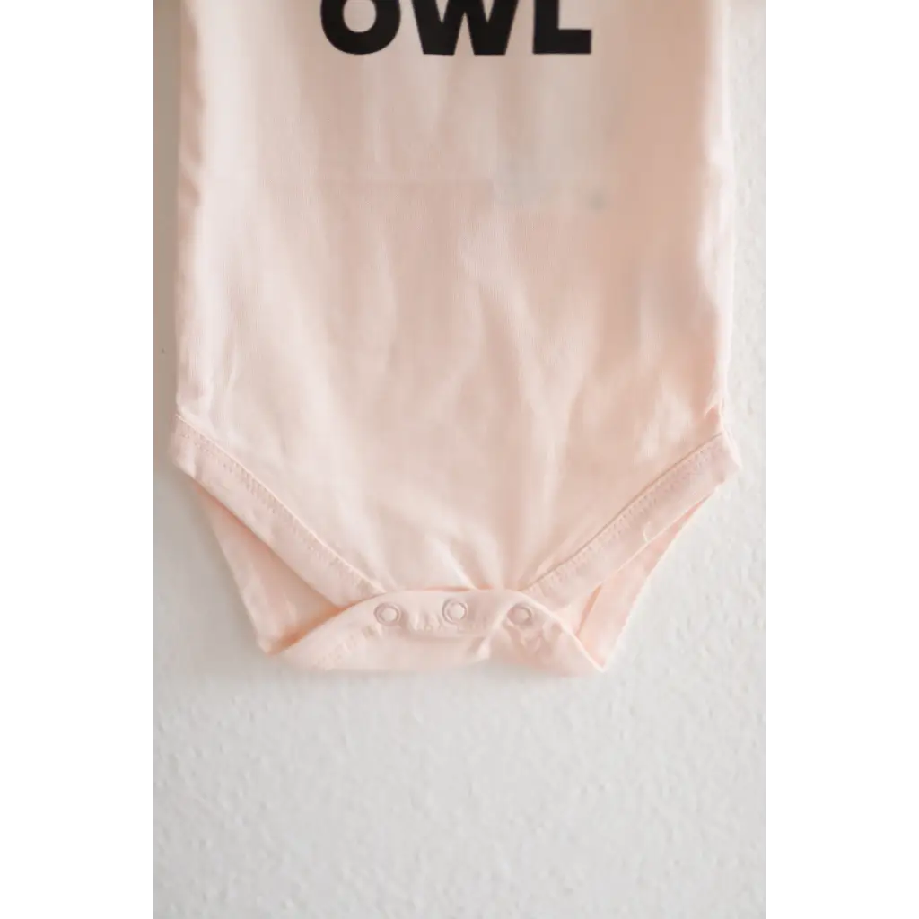 Light pink organic cotton night owl onesie for baby with OWL text at the top