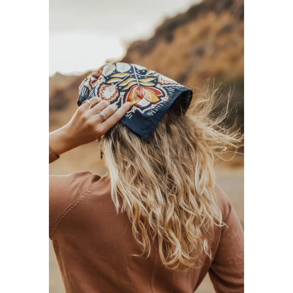 Navy blue bandana with orange floral pattern on blonde hair, perfect for adding style