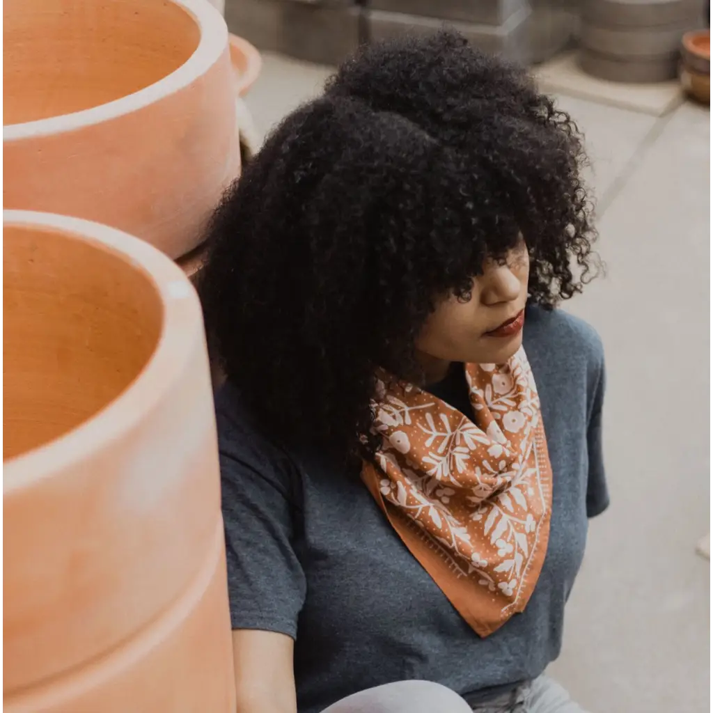 Person rocking a navy shirt and patterned orange Terra Bandana with Polished Prints