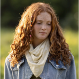 Person with long curly red hair in denim jacket and cream scarf featuring Elena Bandana