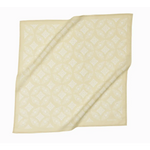 Cream-colored napkin with diagonal folds, perfect for pairing with Elena Bandana in Polished Prints