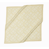 Cream-colored napkin with diagonal folds, perfect for pairing with Elena Bandana in Polished Prints