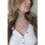 Gold-toned seaside charm necklace with colorful whimsical clay charms for good luck