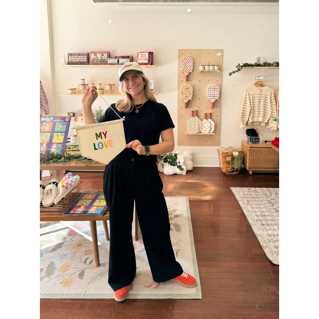 Chic outfit featuring a black t-shirt and wide-leg pants with polished prints and orange socks