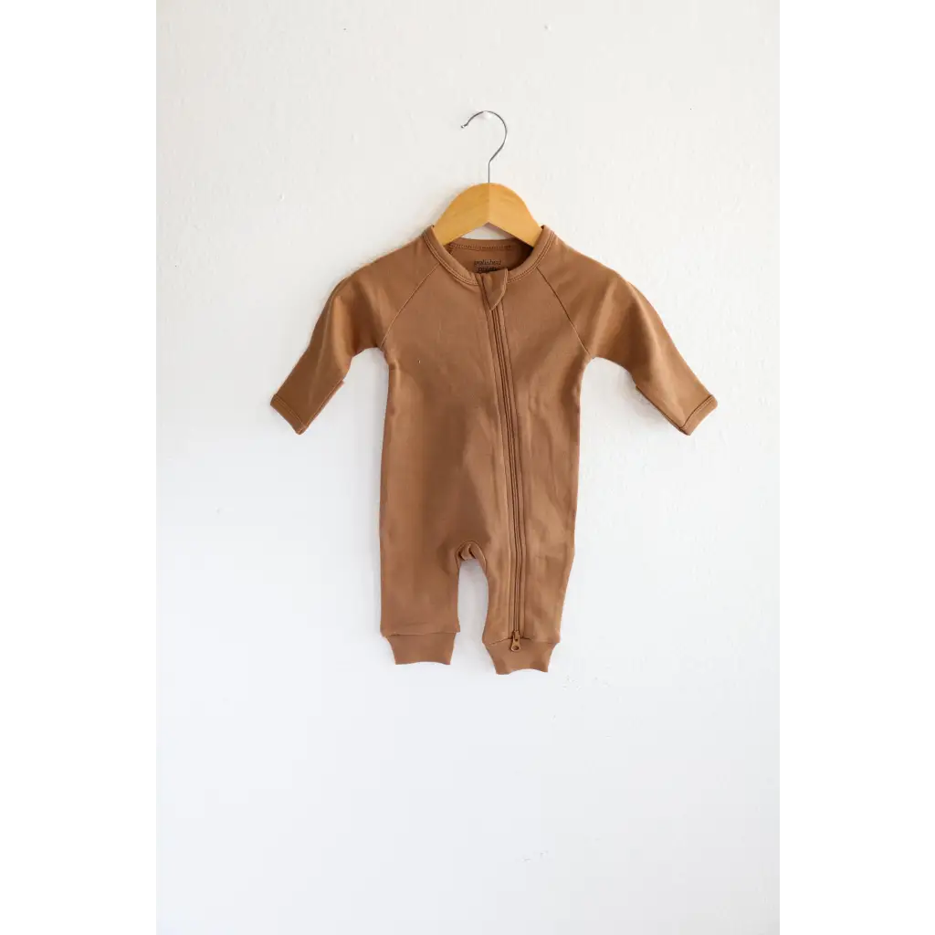 Brown organic cotton baby zipper romper hanging on wooden hanger for comfy cuteness