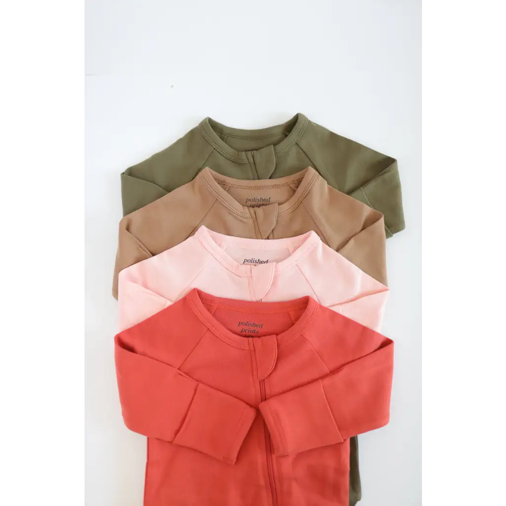 Four long-sleeved shirts in olive green to coral red, made from organic cotton