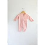 Pink Organic Cotton Baby Zipper Sleeper hanging on a wooden hanger in earthy colors