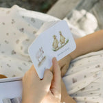 Child’s hand holding flashcards with animal illustrations from Our Very Little Library board book set