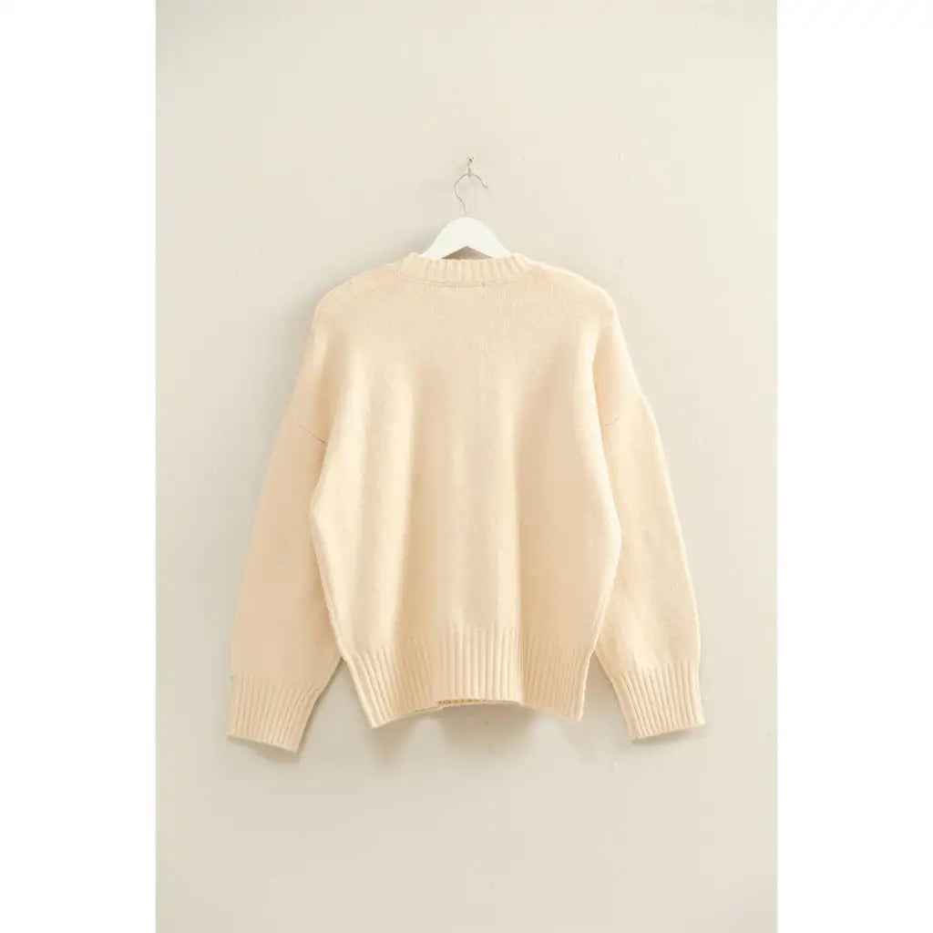 Cream-colored oversized drop shoulder sweater with ribbed cuffs