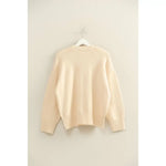 Cream-colored oversized drop shoulder sweater with ribbed cuffs