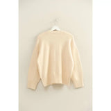 Cream-colored oversized drop shoulder sweater with ribbed cuffs