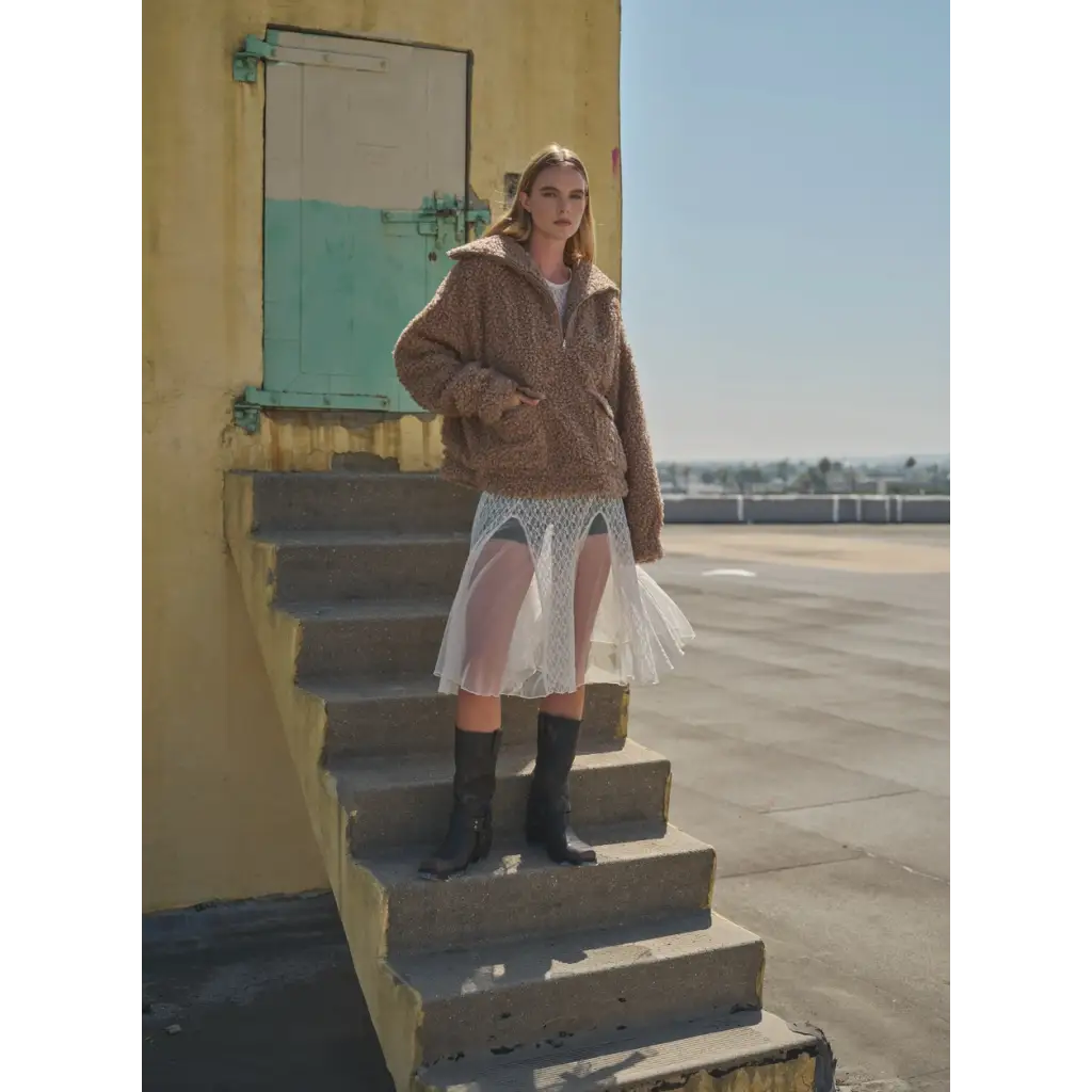 Person in a brown jacket and white skirt showing off the Oversized Teddy Quarter Zip Up