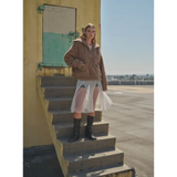 Person in a brown jacket and white skirt showing off the Oversized Teddy Quarter Zip Up