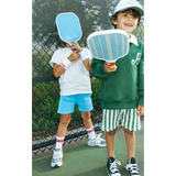 Two kids having fun in their kids embroidered polo, holding blue pickleball paddles