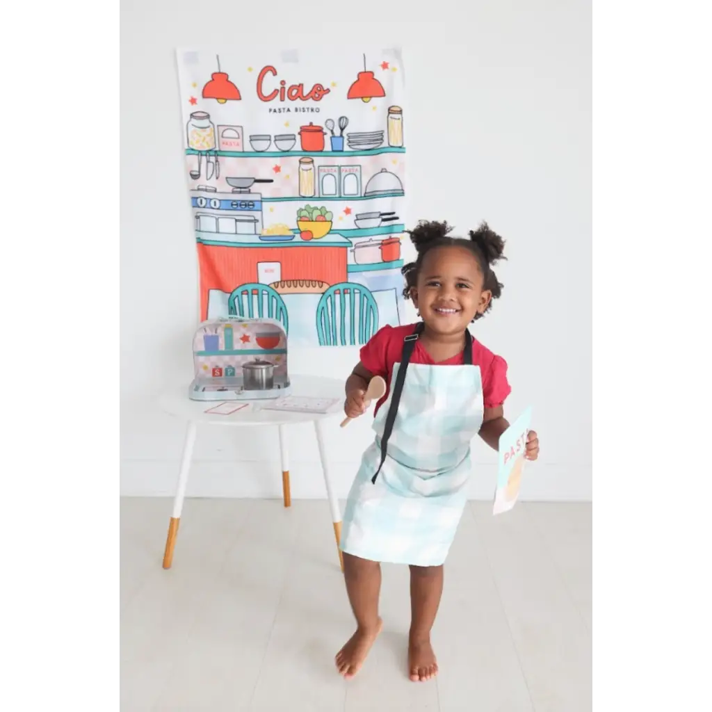 Young chef in blue apron and red shirt from Pasta Shop Play Kit for pretend play fun