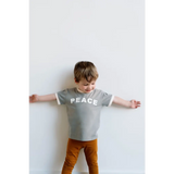 Child in gray PEACE t-shirt and brown pants showcasing Retro-inspired Everyday Ringer Tee