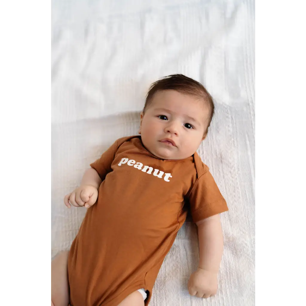 Baby in Peanut Organic Cotton Onesie showcasing cute peanut text design