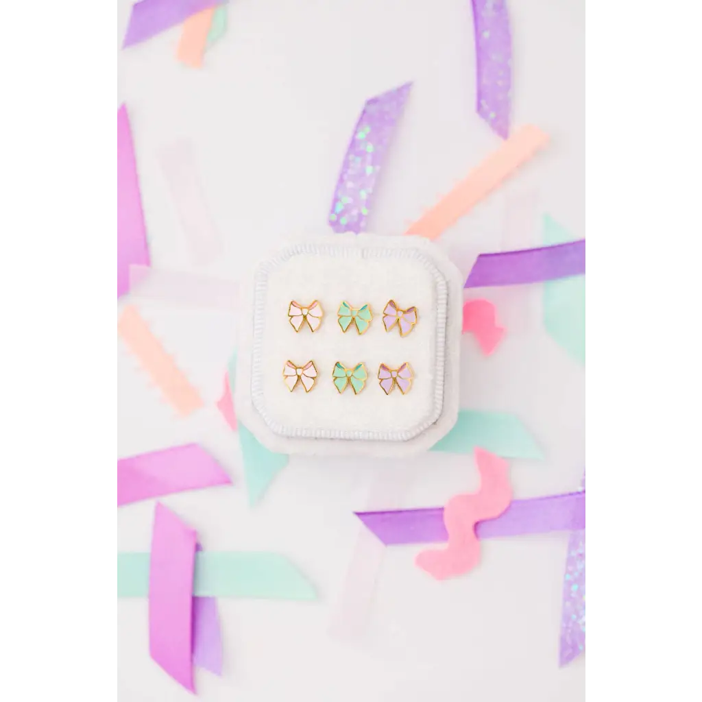 Gold bow stud earrings with colorful enamel in display case