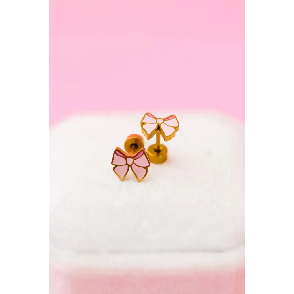 Shiny gold and pink bow stud earrings with glossy finish