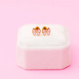 Pink bow stud earrings with gold accents in stylish womens clothes box