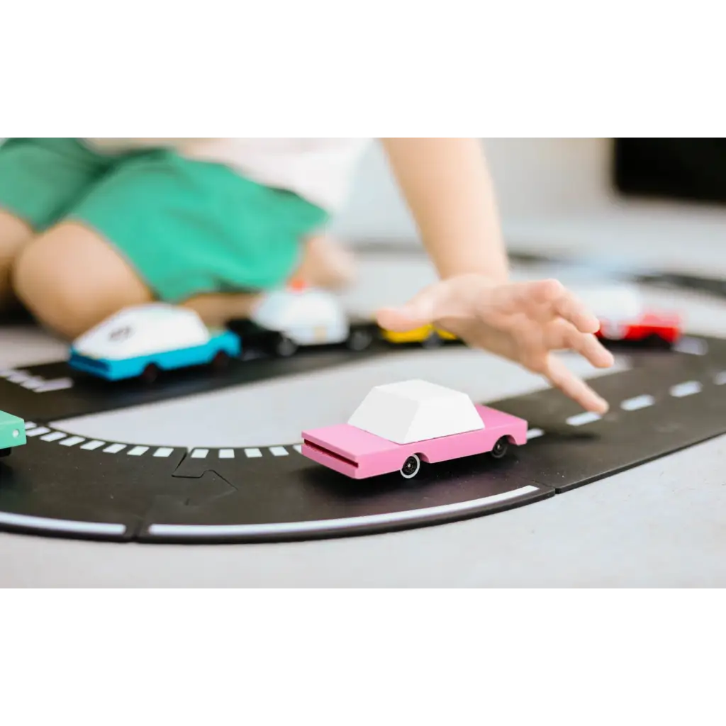 Pink Sedan toy car on black track, made of solid beech wood with clear urethane coat