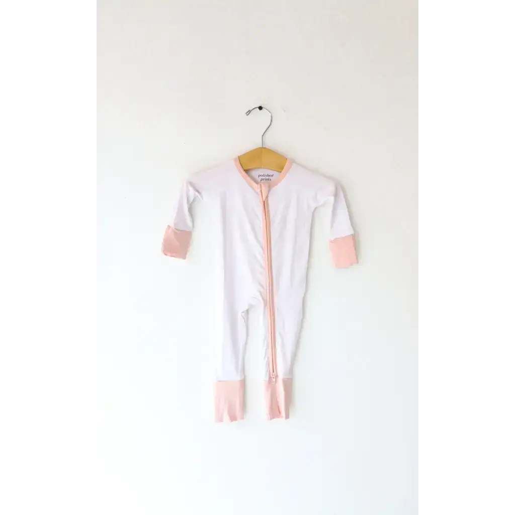 White baby onesie with pink trim, perfect bamboo baby sleeper for comfy naps