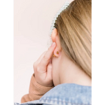 Hand touching an ear with a pearl earring, perfect hypoallergenic earrings for active girls