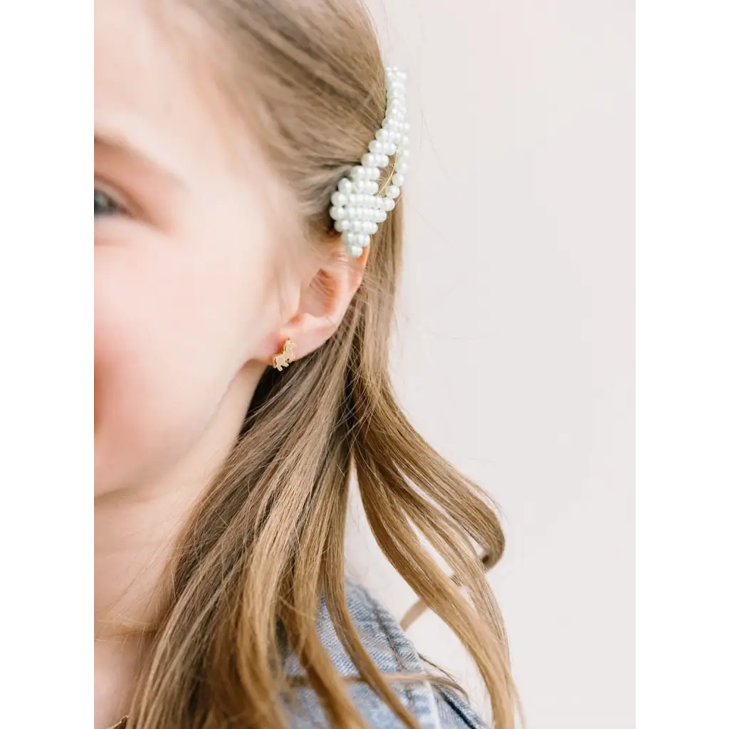 Pearl-beaded hair clip with blonde hair next to hypoallergenic earrings for active girls