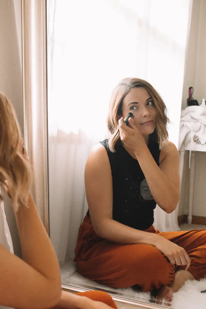 woman applying makeup in a mirror