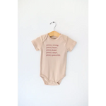 Tan baby onesie with empowering text made from Pretty Brave Organic Cotton