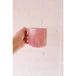 Hand holding a pink ceramic mug with a cute bow design, perfect for your campfire mug collection