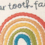 Hand-embroidered rainbow tooth fairy pillow in vibrant threads on cream fabric