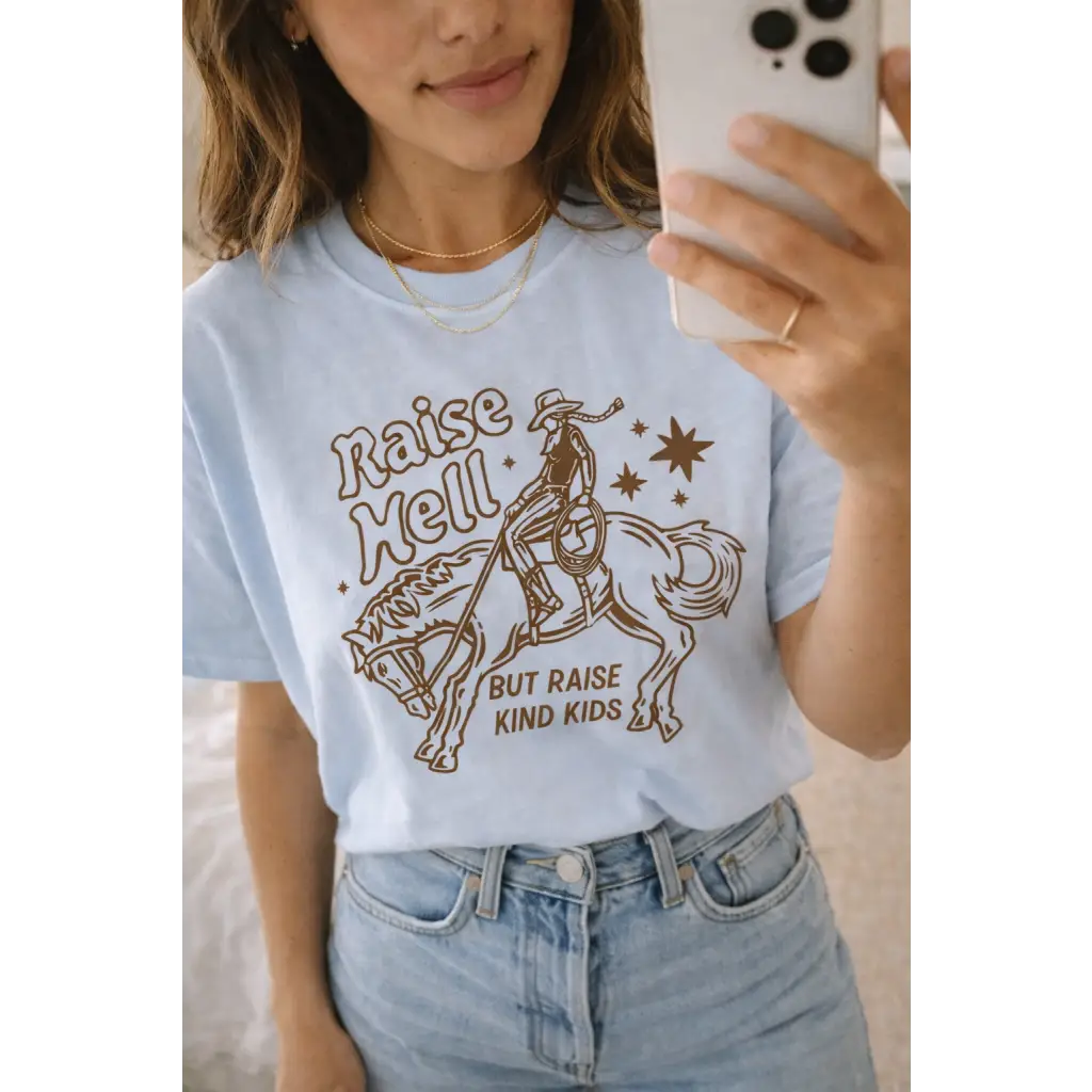 Light blue oversized unisex tee with cowboy graphic and raise hell but raise kind kids text