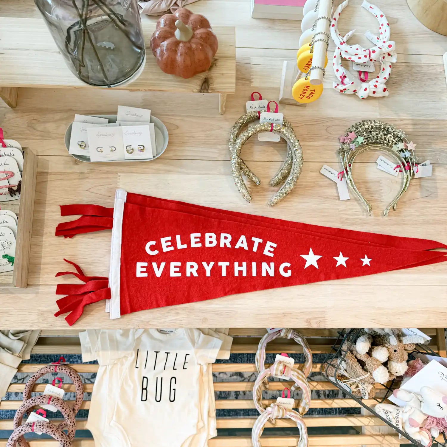 Red felt pennant with white text reading ’CELEBRATE EVERYTHING’ and stars.