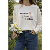 Cream-colored Respect Your Elders pullover with polished prints and broken-in feel