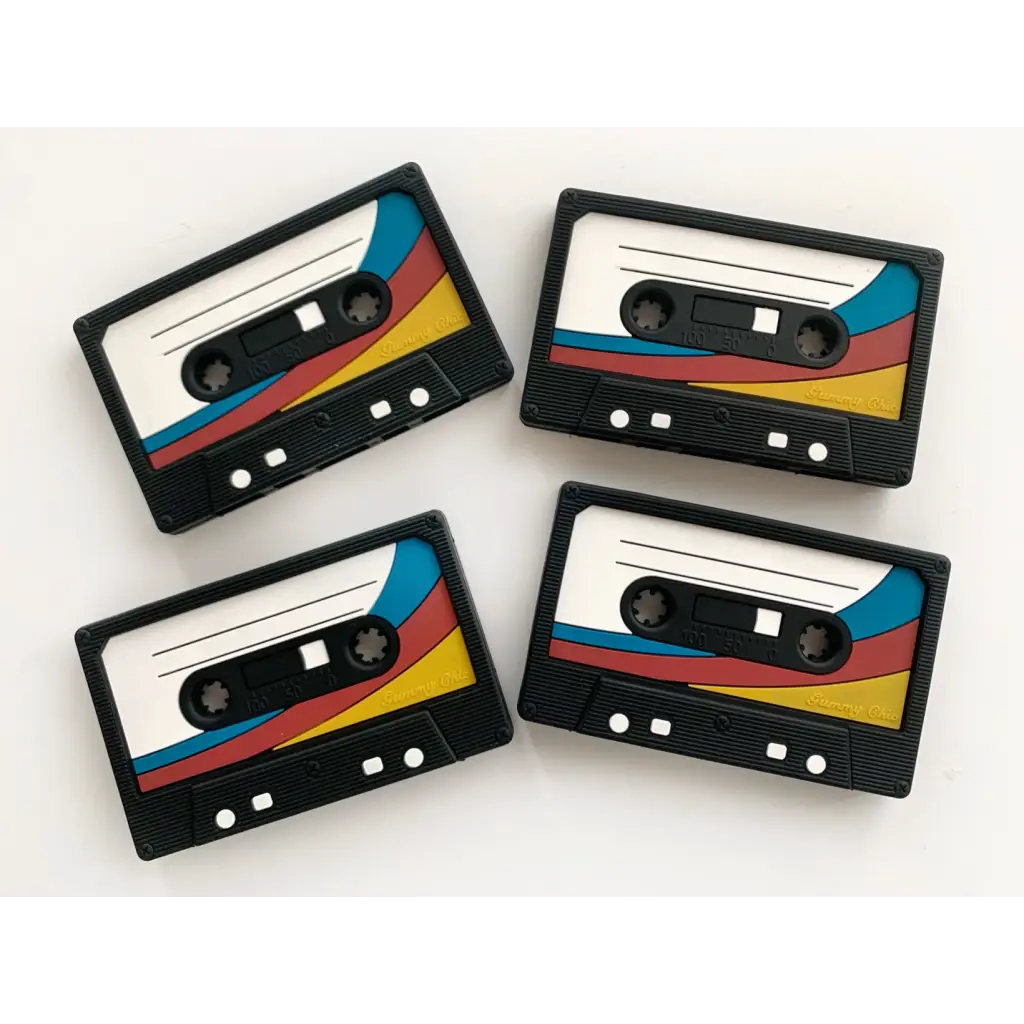 Four retro cassette tapes with colorful stripes in a fun cassette tape teether for babies