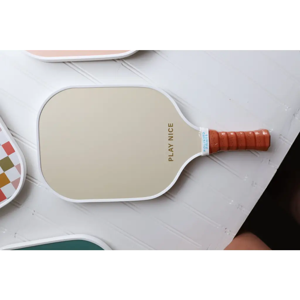 White pickle ball paddle with orange grip for fun Vintage-style Pickle Ball Game