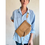 Tan leather Roxie Saddle Crossbody Bag, perfect for stylish women’s clothes and polished prints